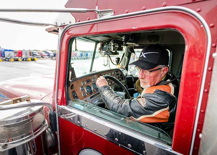 Truck driver in cab of red truck